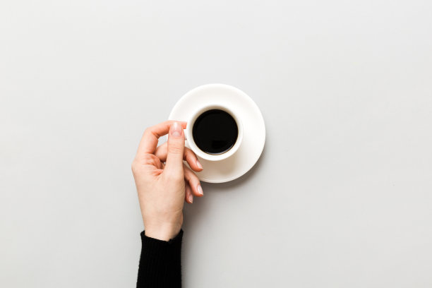 极简风格的女人手拿一杯咖啡在彩色背景。平铺，俯视浓缩咖啡杯。文字空白的地方，复制的空间。咖啡上瘾。俯视图，平铺图片下载