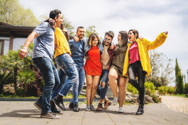 一群多民族的快乐的朋友拥抱在一起，愉快地走在一起图片下载