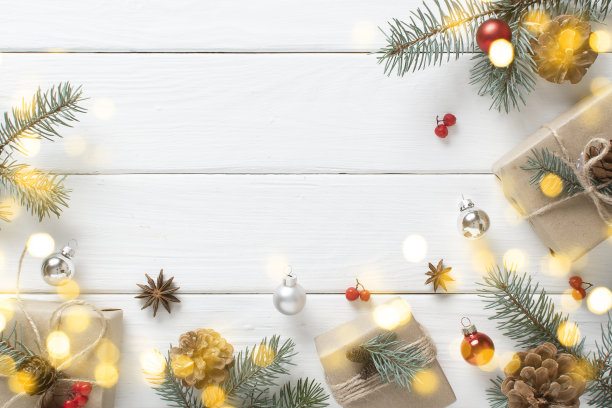 一份用牛皮纸包裹的圣诞礼物，用天然材料装饰，放在一个白色的木制桌子上，上面有一个节日的焦景。图片下载