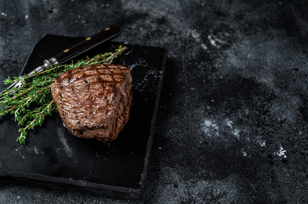 烤牛排配香料，熟牛肉。黑色背景。前视图。本空间图片下载