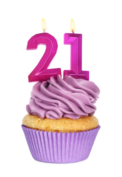 美味的纸杯蛋糕，白色背景上有数字形状的蜡烛。成人派对- 21岁生日图片下载