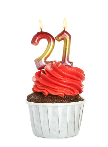美味的纸杯蛋糕，白色背景上有数字形状的蜡烛。成人派对- 21岁生日图片下载