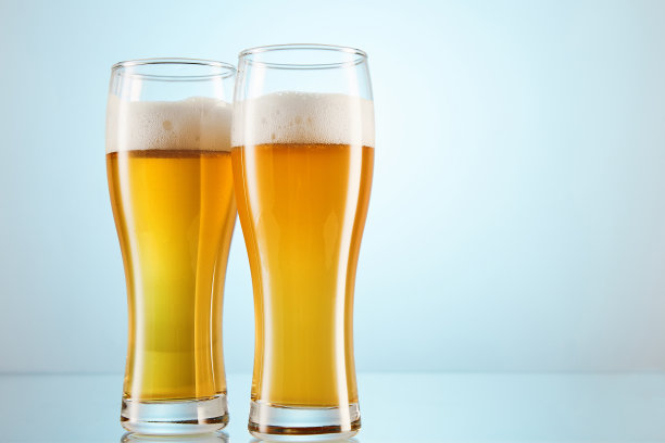 黄色酒精碳酸饮料，酿满玻璃杯至边缘。图片下载