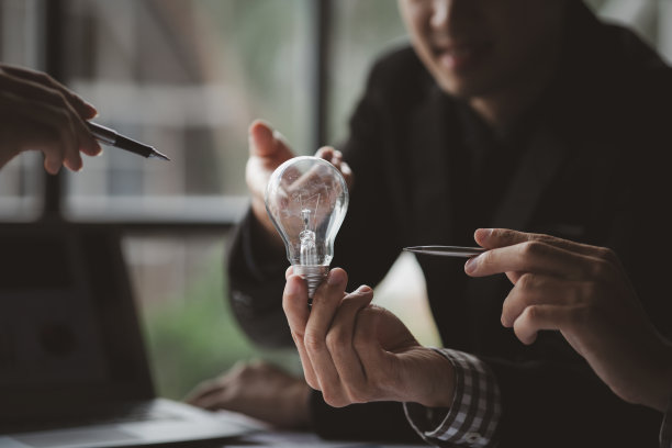 商人举着发光的灯，创意新点子。创新，头脑风暴，制定战略，使业务增长和盈利。概念执行、战略规划、利润管理。图片下载