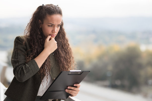 妇女拿着文件活页夹，想着工作图片下载