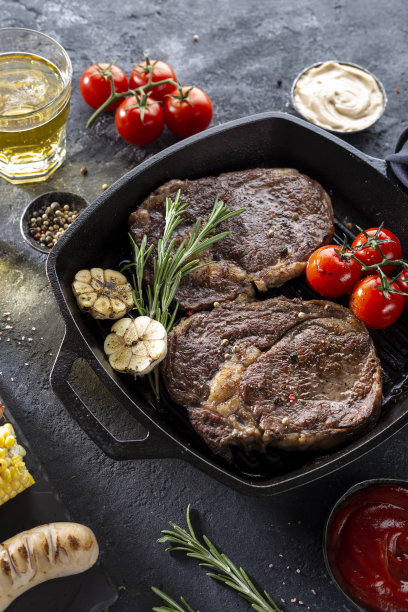 烤肋眼牛排在煎生铁烧烤锅在黑色背景图片下载