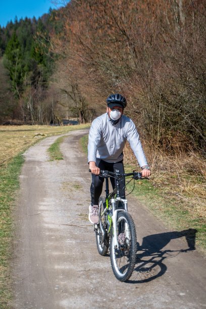 冠状病毒/COVID-19大流行期间，一名戴口罩的男子骑自行车。图片下载