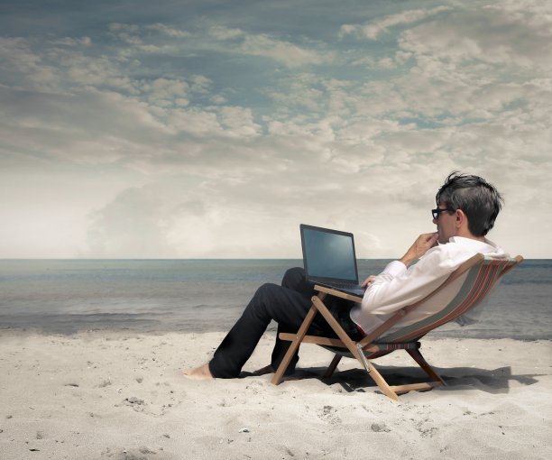 有人在海滩上用笔记本电脑工作图片下载