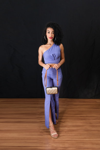 年轻美丽的肖像，快乐的女人站在工作室。拿着一个袋子。图片下载