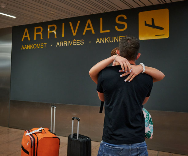 年轻快乐的西班牙男子在机场拥抱她的女朋友图片下载