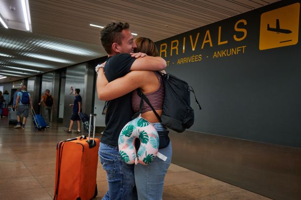 年轻快乐的西班牙男子在机场拥抱她的女朋友图片下载
