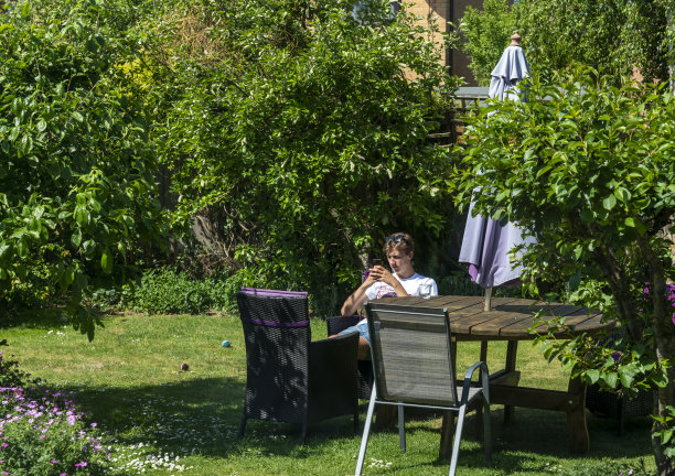 炎炎夏日，一个年轻人在住宅花园休息图片下载