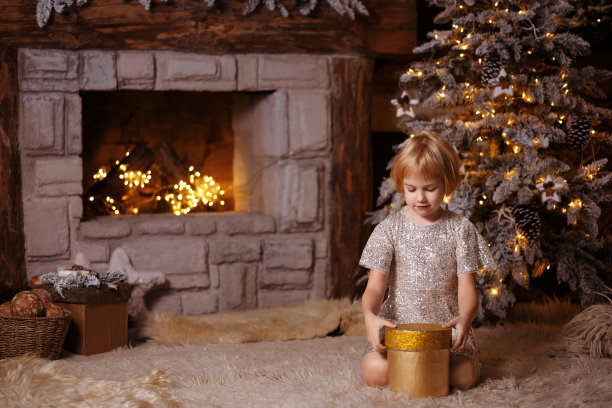 穿着裙子的孩子打开礼物。图片下载