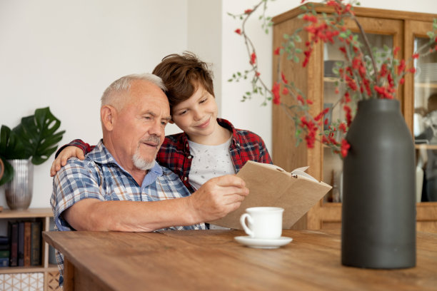 爷爷和他的小学生孙子一起读一本样书图片下载