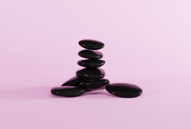 粉色背景上的黑色按摩石。图片下载