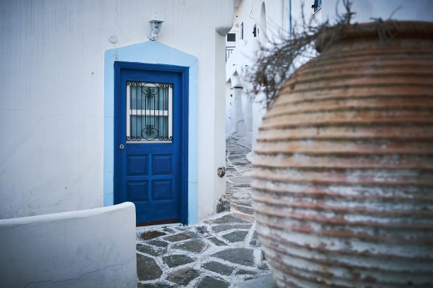 这是希腊帕罗斯市狭窄街道上一座白色建筑和一扇蓝色门的美丽照片图片下载