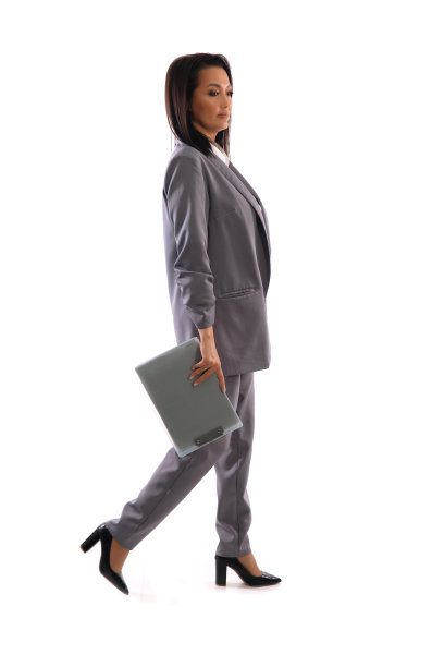 穿着灰色西装的商务女士拿着白色背景的文件夹走着图片下载