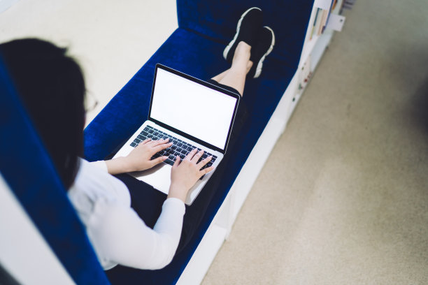 女士坐在办公室的长凳上使用笔记本电脑图片下载