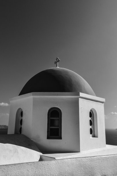 在宁静的天空下，教堂圆顶和十字架的垂直灰度照片图片下载