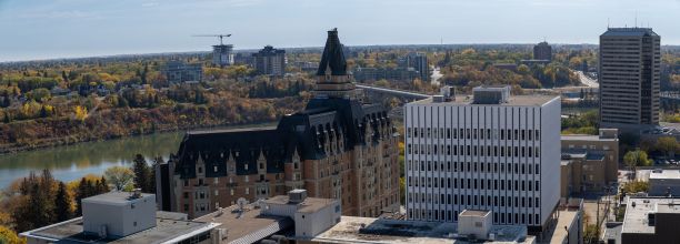 秋天，加拿大萨斯卡通的河流、密集的建筑和树木的全景照片图片下载
