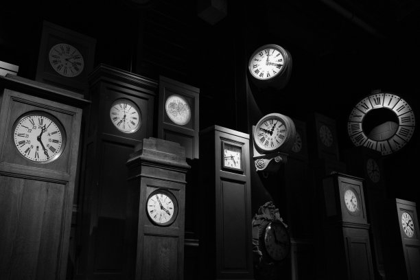在黑暗的背景下，在一个黑暗的房间里的大型时钟的灰度镜头图片下载
