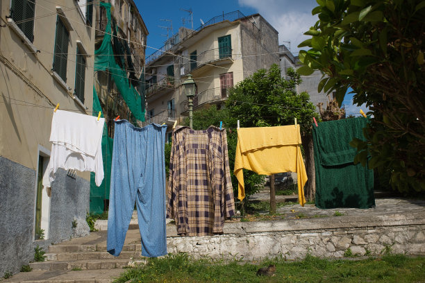 在希腊科福的老建筑前，一幅五颜六色的衣服挂在洗衣索上的照片图片下载