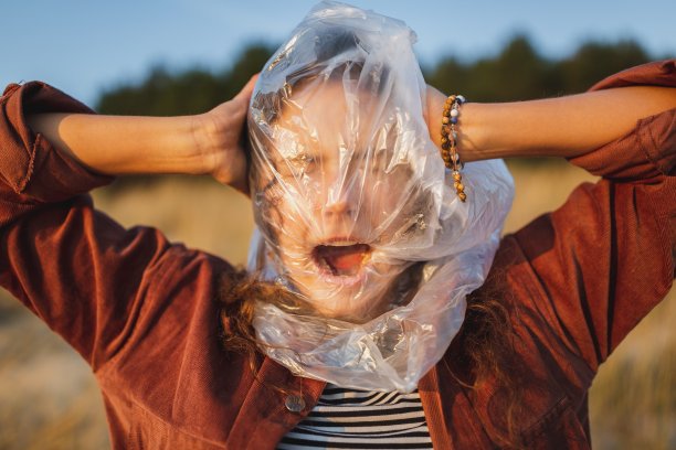 一个模特脸上蒙着塑料袋，强调环境问题图片下载