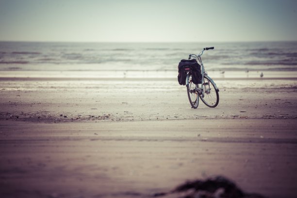 美丽的照片，一辆孤立的自行车停在海岸在一个多云黑暗的天气图片下载