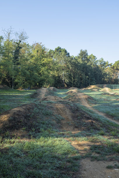 一些凸起的绿色田野景观上的山地自行车道电路图片下载