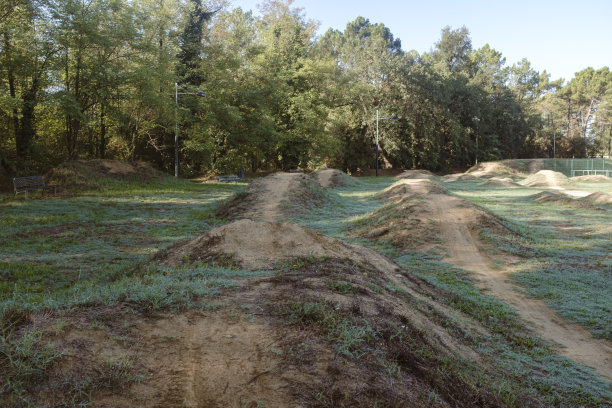 一些凸起的绿色田野景观上的山地自行车道电路图片下载