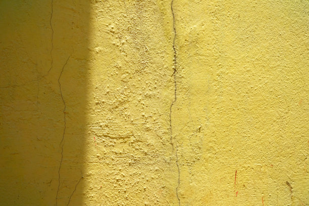 阳光光束在垃圾黄色油漆混凝土墙背景。图片下载