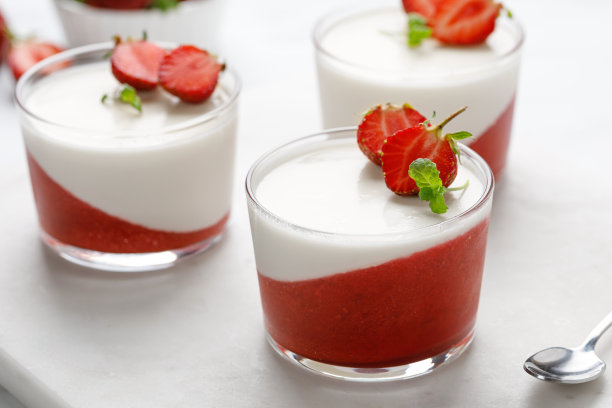 用新鲜浆果和薄荷装饰的玻璃罐里的草莓意式奶冻，传统的意大利甜点。草莓奶油甜点——意式奶冻。图片下载