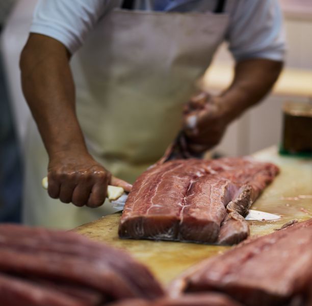 屠夫在商店里切一大块肉图片下载