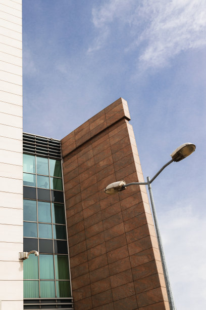 城市建筑和路灯在蓝天下的垂直图像图片下载