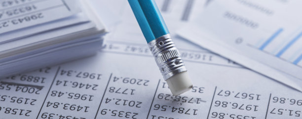 用橡皮擦会计文件，擦去文件上的污点，检查财务图表。银行、财务报告和财务审计的概念。图片下载