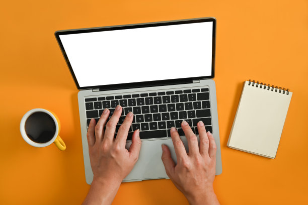 从上面黄色背景的男子使用笔记本电脑的视角。白色空屏幕为您的广告设计。图片下载