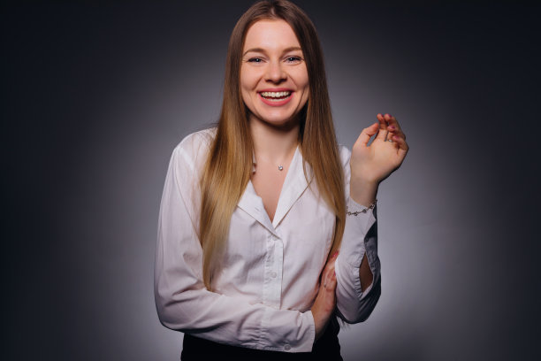 一个年轻女子的肖像，穿着白色的衬衫，面带美丽的微笑图片下载