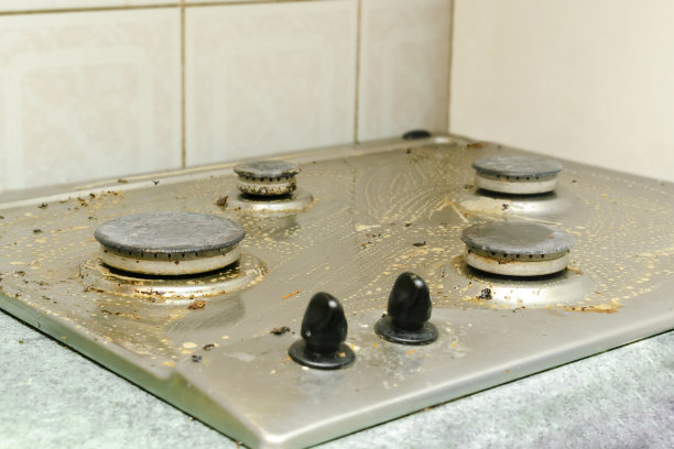 清理脏煤气炉上的油脂，剩饭剩菜。清洗厨房灶台。家居清洁服务理念图片下载