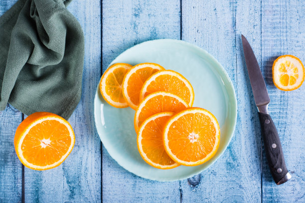 圆形的鲜橘片放在桌子上的盘子里。维生素抗氧化饮食。俯视图图片下载