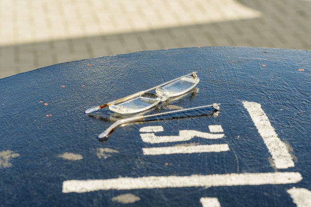 碎玻璃杯放在一张黑色的金属桌子上，上面写着“三十一”。图片下载