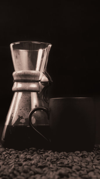 咖啡酿造壶在一个暗黑色的背景，一杯咖啡和咖啡豆在它下面。图片下载
