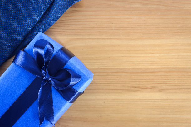 顶视图蓝色礼盒与丝带和领带的木制背景与复制空间。图片下载