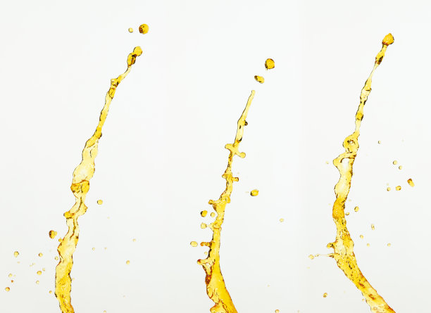 橙汁、柠檬汁或油润滑剂飞溅，液体金黄色饮料滴。水果饮料水元素呈直线形式。新鲜的飞溅和流动的射流，白色的背景孤立的冻结运动图片下载