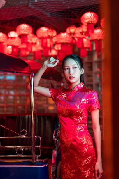 工作室肖像照片的美丽年轻的亚洲女性模特穿着优雅的红色传统中国服装旗袍服装与冷静的情绪看站在一辆嘟嘟出租车车辆旁边图片下载