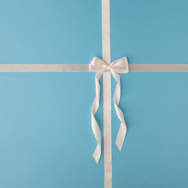 白色缎带蝴蝶结蓝色背景。图片下载