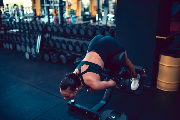 运动女性在健身房做背部伸展运动图片下载