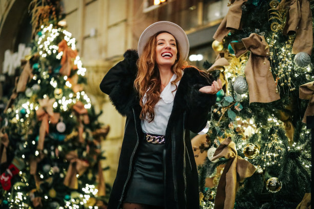 微笑的时尚女性在城市里享受圣诞节图片下载