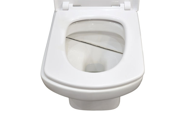 家里浴室的抽水马桶有裂缝，在白色背景上孤立。家里厕所里的破碗图片下载