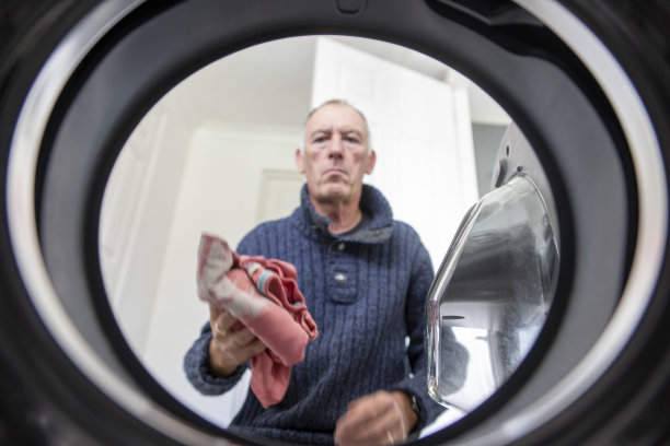 老人正在把衣物放进洗衣机图片下载