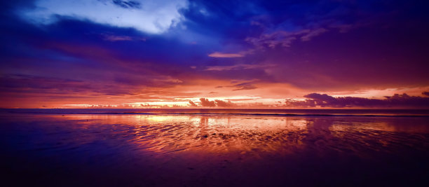 长他海滩的日落全景。多云的天空。在海边的最后一小时。图片下载